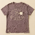Violet t-shirt destroyed by a shotgun blast spreading across the chest, print mostly gone — flat lay