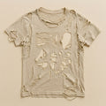 Pale oatmeal t-shirt worn into a lace of holes, held together only by its seams — flat lay